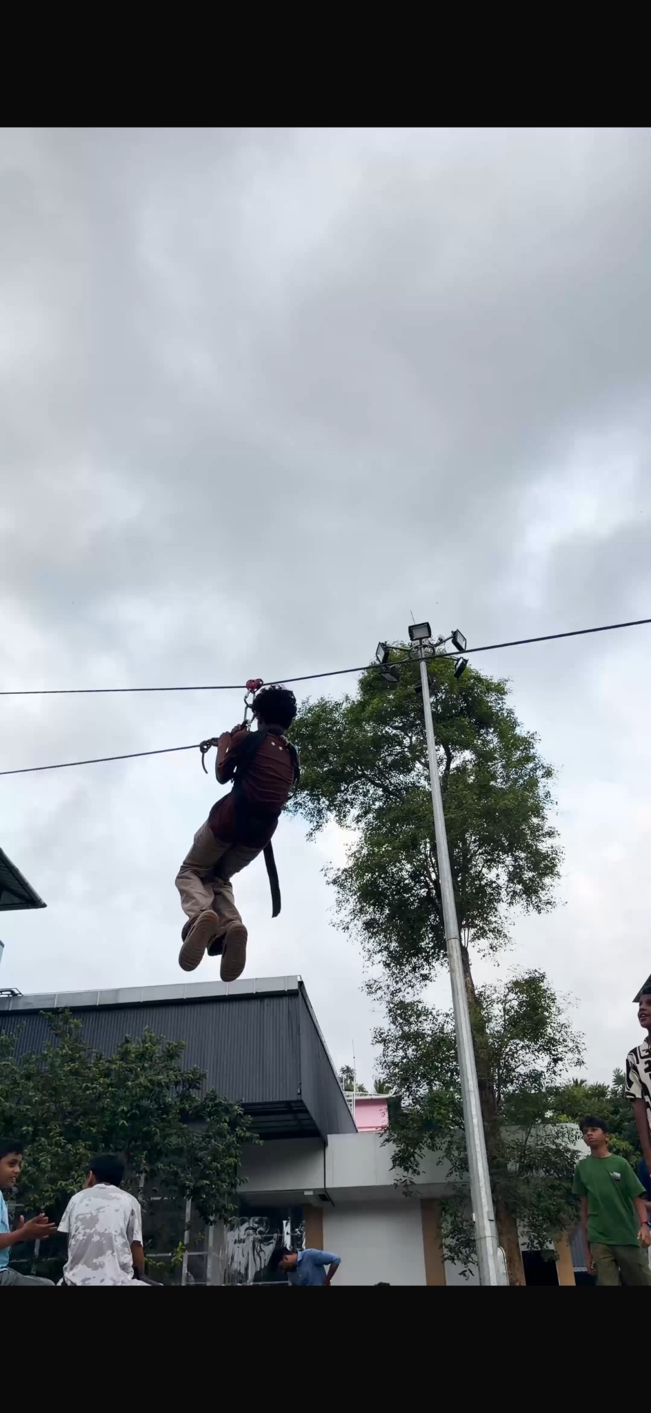 A camper on a zipline above the camp grounds.