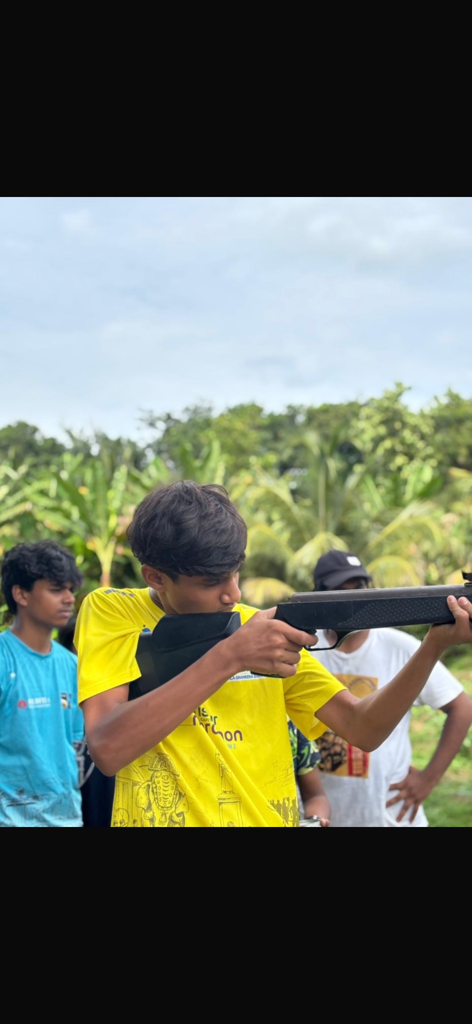 A participant aiming an air rifle during camp target practice.